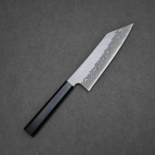 A 180mm Nigara tsuchime damascus VG10 bunka knife with a Damascus steel patterned blade and a black octagonal handle rests elegantly on a dark textured surface.