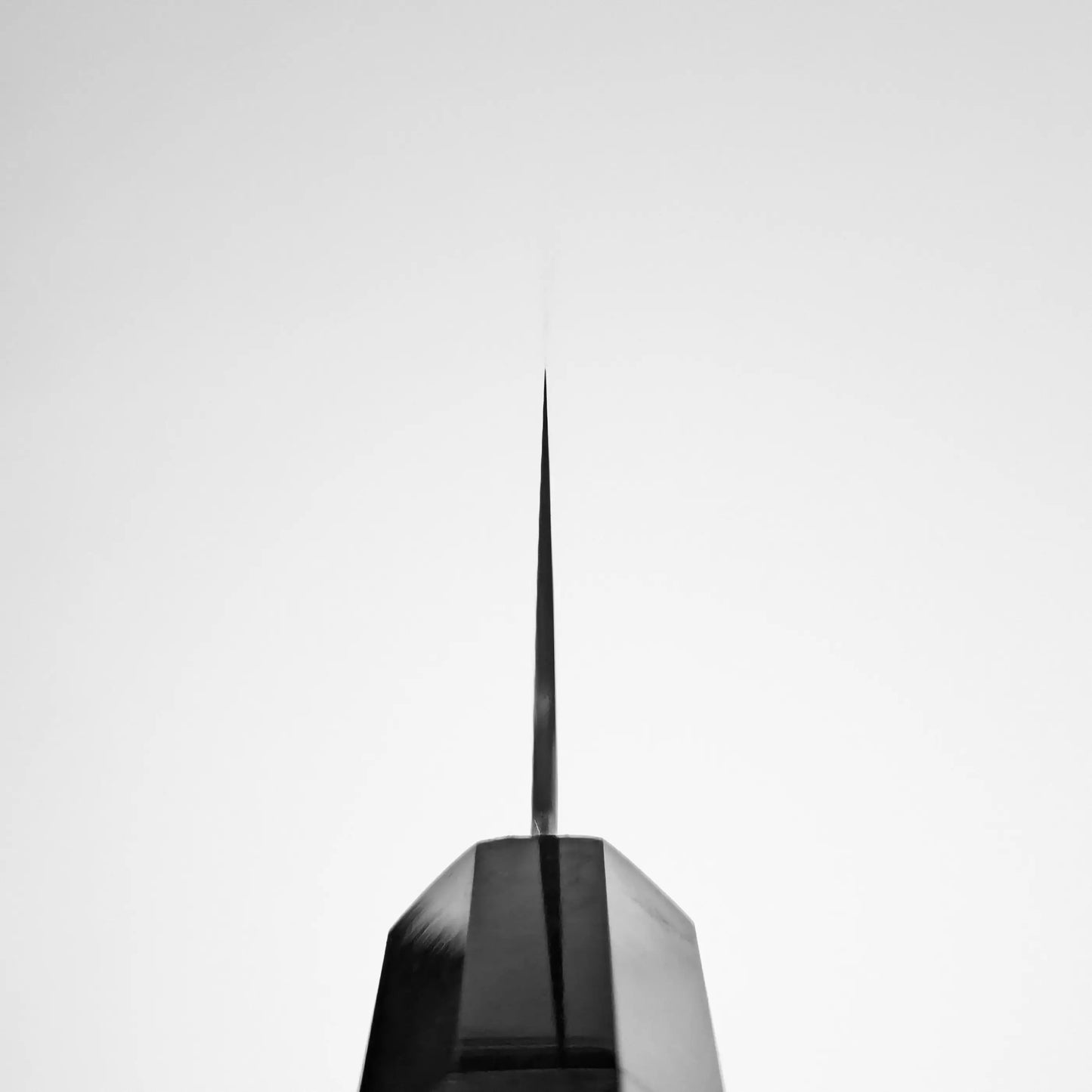 Close-up of a syringe needle tip against a plain light background, highlighting sharpness and edge retention reminiscent of the Hatsukokoro FAXR2 gyuto 240mm by Hatsukokoro.