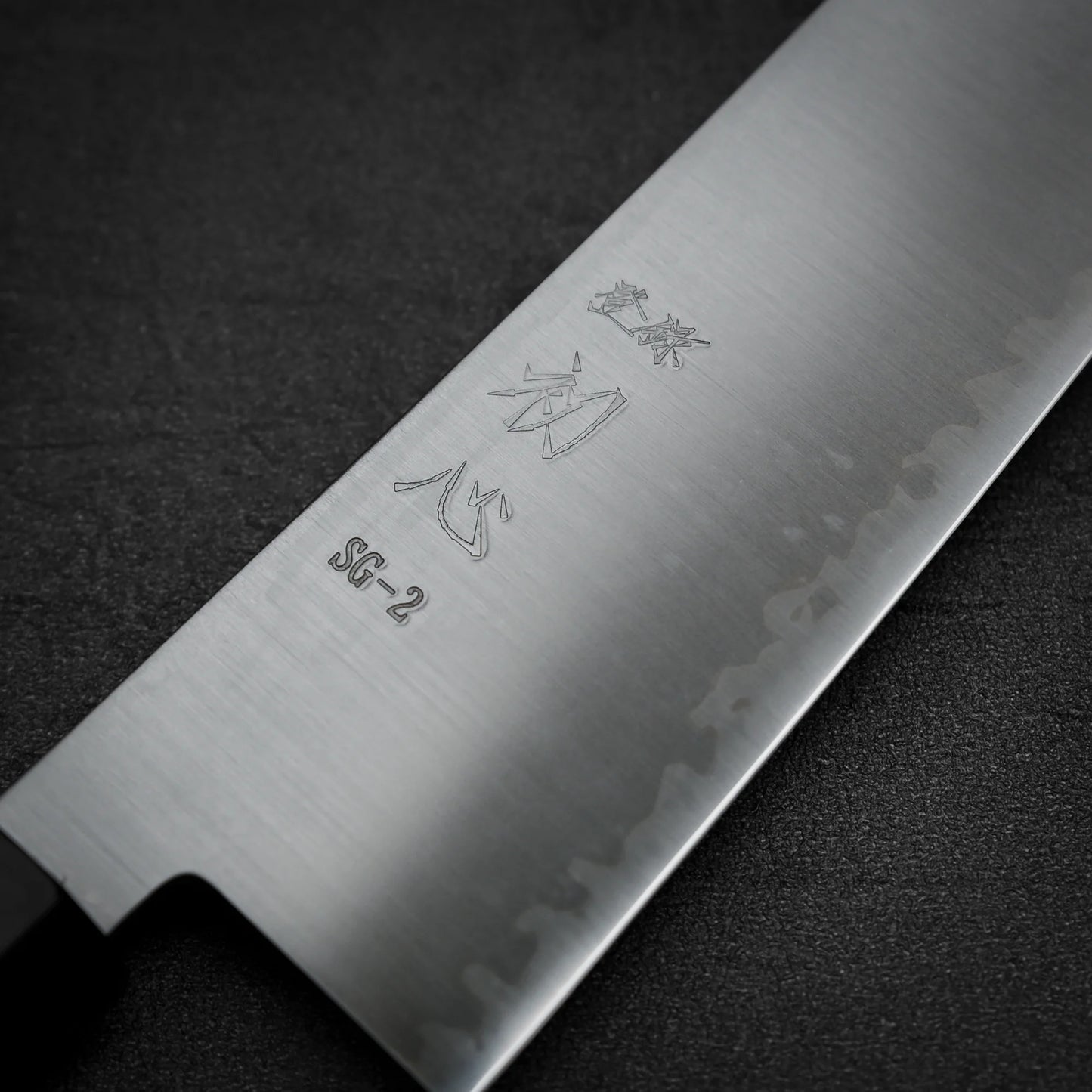Macro shot of the kanji area of Hatsukokoro Hayabusa SG2 gyuto knife