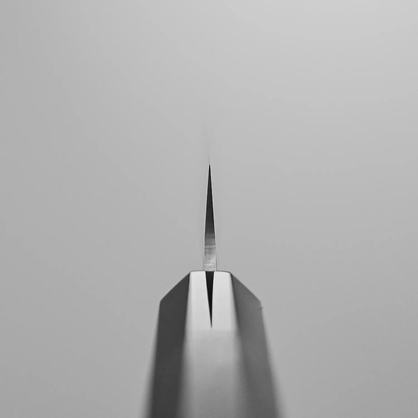 A close-up, straight-on view of the Hatsukokoro Hayabusa tsuchime VG10 petty knife 150mm blade, centered with its sharp edge highlighted against a plain light gray background.
