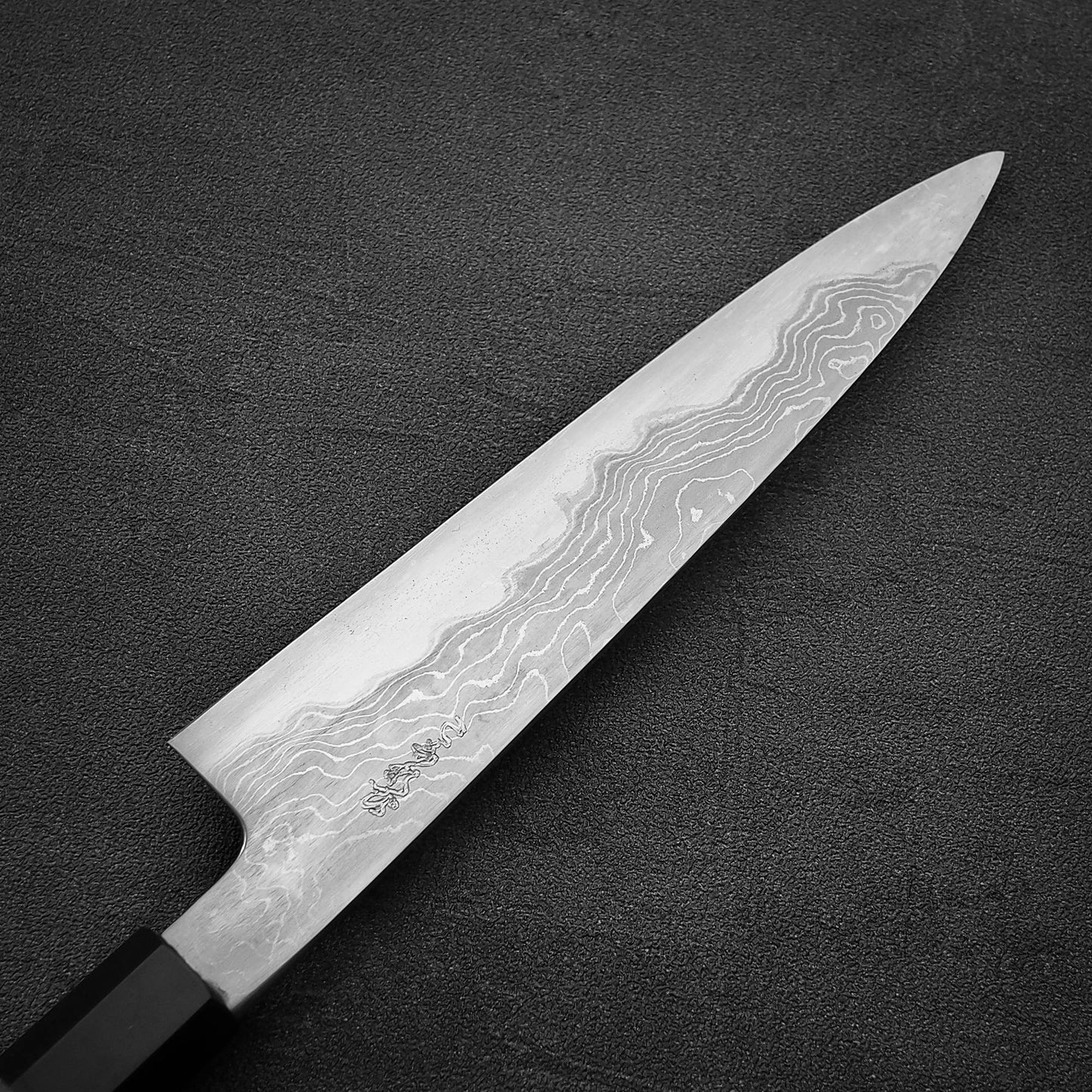 Close up view of the back side of Hatsukokoro Komorebi damascus aogami#1 petty knife