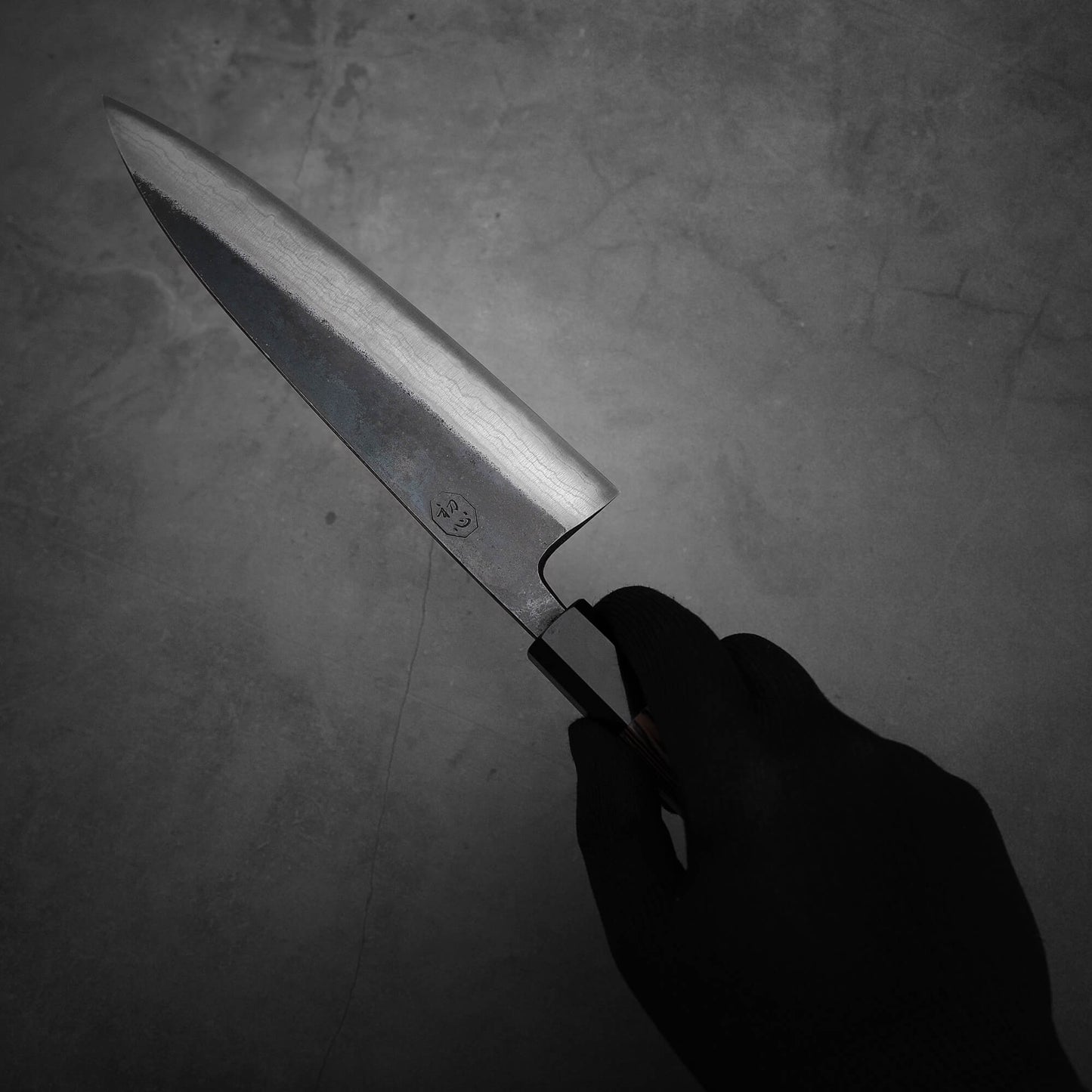 Hand holding Hatsukokoro Kumokage gyuto knife