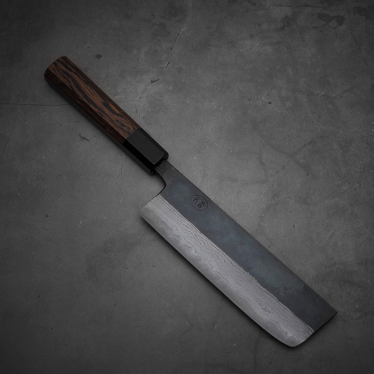 Top view of Hatsukokoro Kumokage kurouchi damascus aogami#2 nakiri knife where the front area is facing lower right