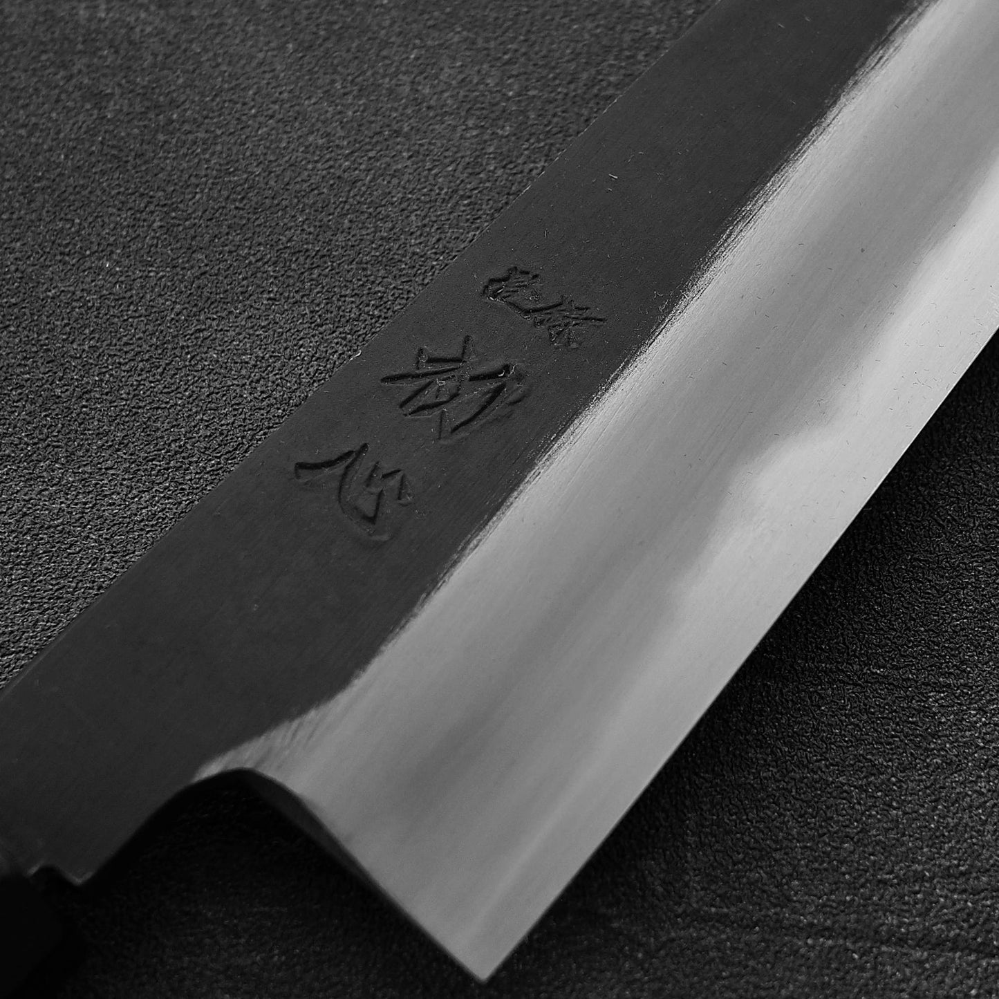 Close up view of the kanji of Hatsukokoro Yoake kurouchi aogami#1 kiritsuke gyuto knife