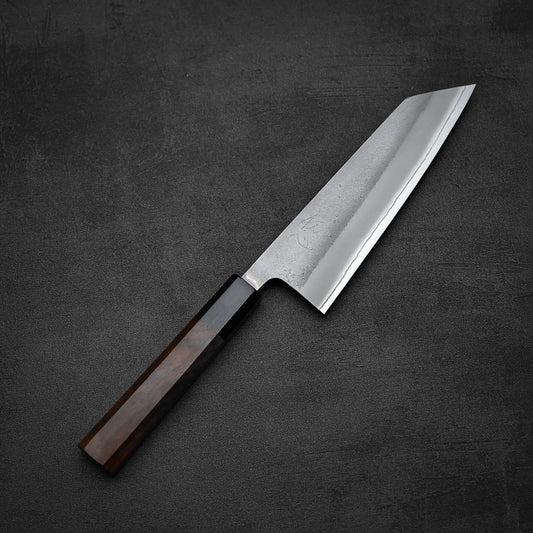 The Yoshikane Hatsukokoro nashiji shirogami#2 bunka 165mm, featuring a rectangular wooden handle and a wide, straight-edged stainless steel blade, rests on a dark textured surface.