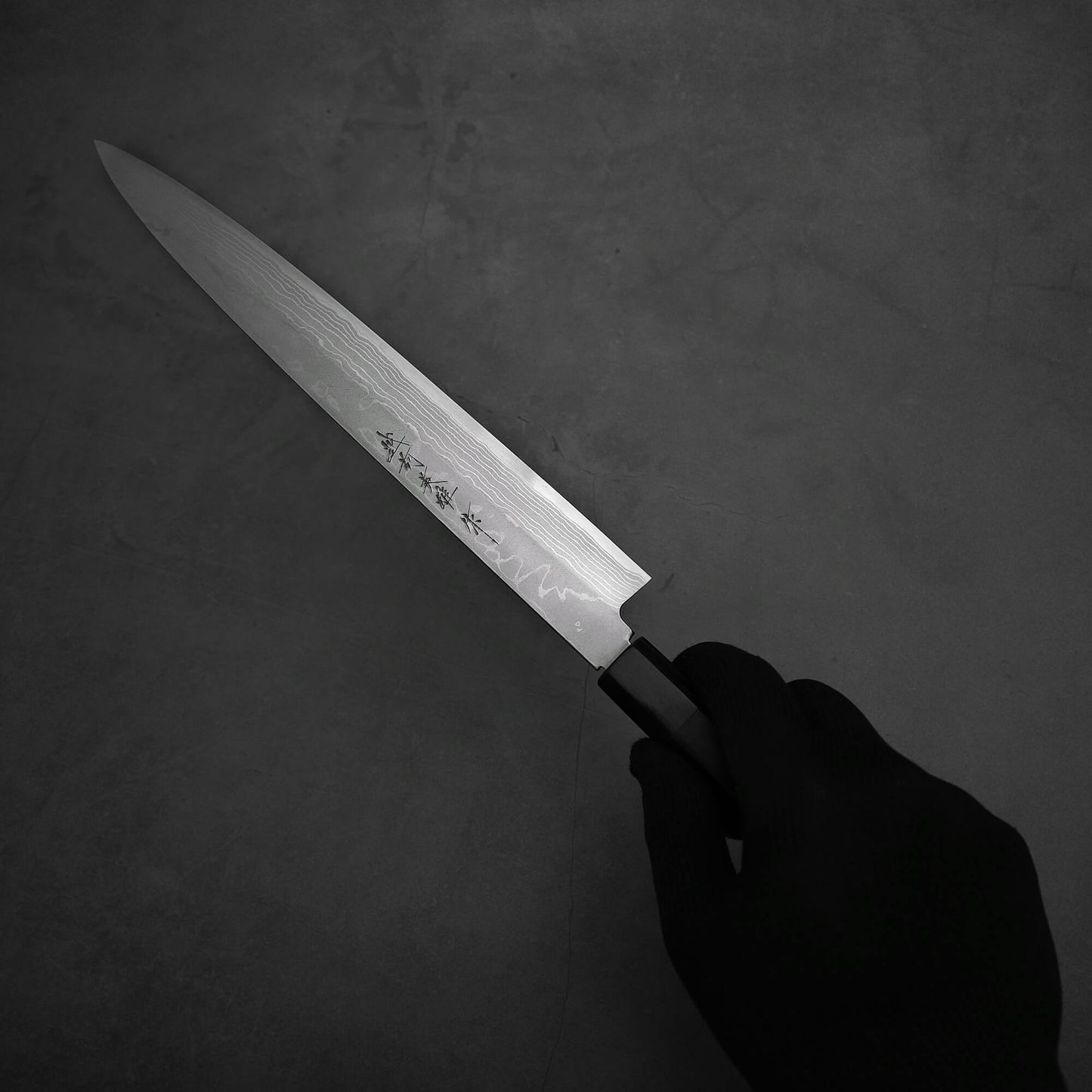 Hand holding the Hideo Kitaoka damascus shirogami#2 yanagiba 270mm