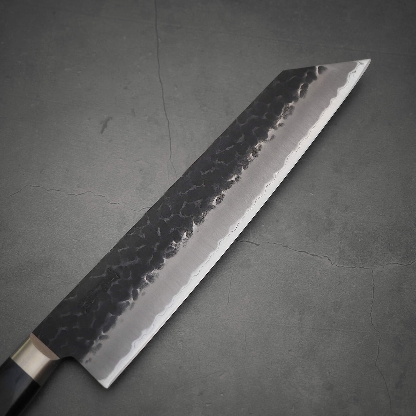 Top view of Ittosai Kotetsu tsuchime kurouchi aogami super kiritsuke gyuto. Image shows the right side of the blade