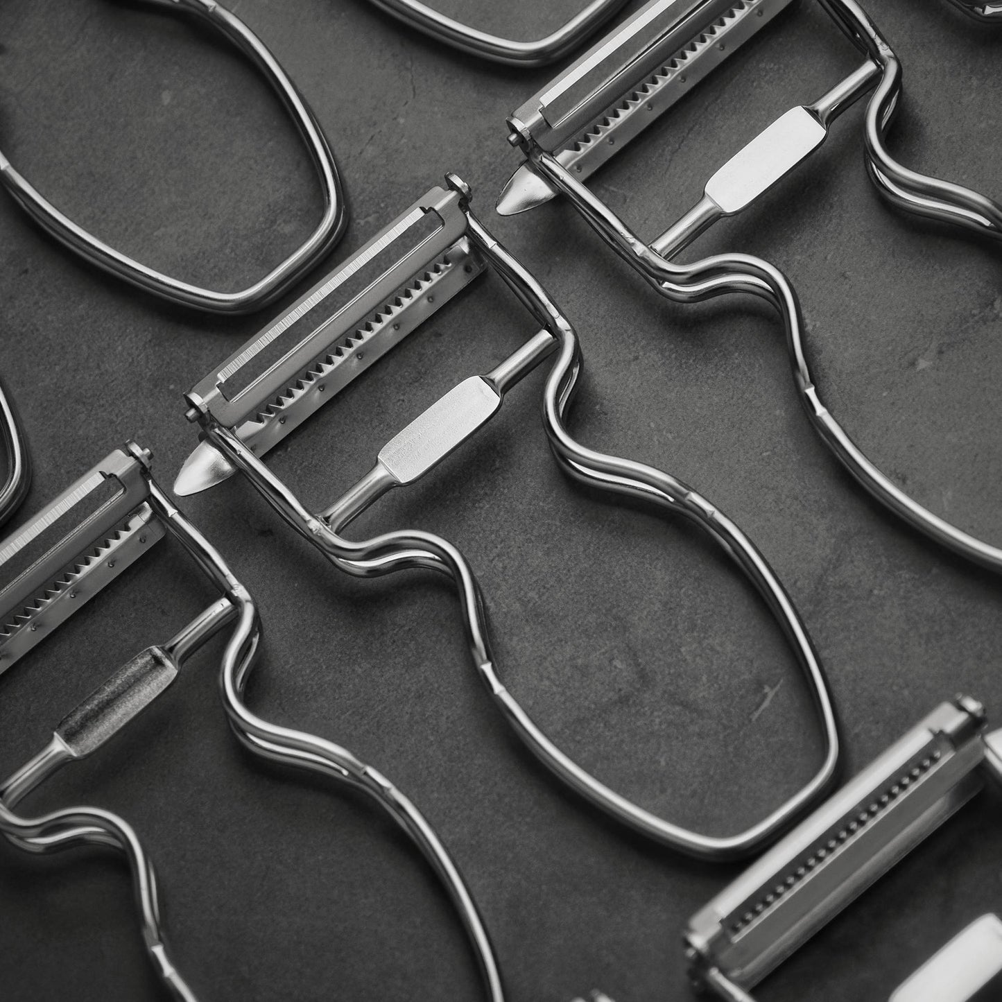 Top down view of several Kankuma Tsuma and Peeler: A versatile Japanese kitchen tool for peeling and creating tsuma cuts. Made in Japan.