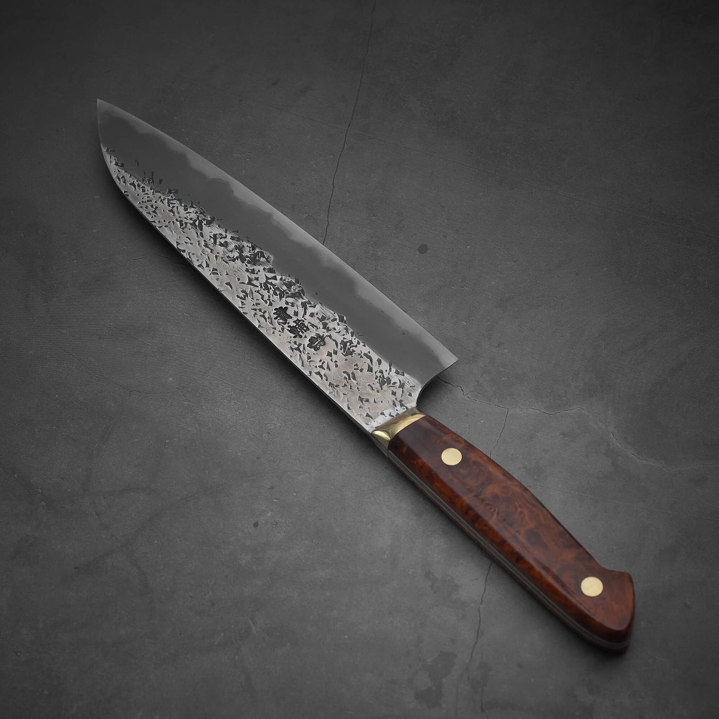 Top view of a 220mm Kisuke Manaka tsuchime honwarikomi shirogami#2 gyuto knife. The pointed tip is facing towards the upper left.