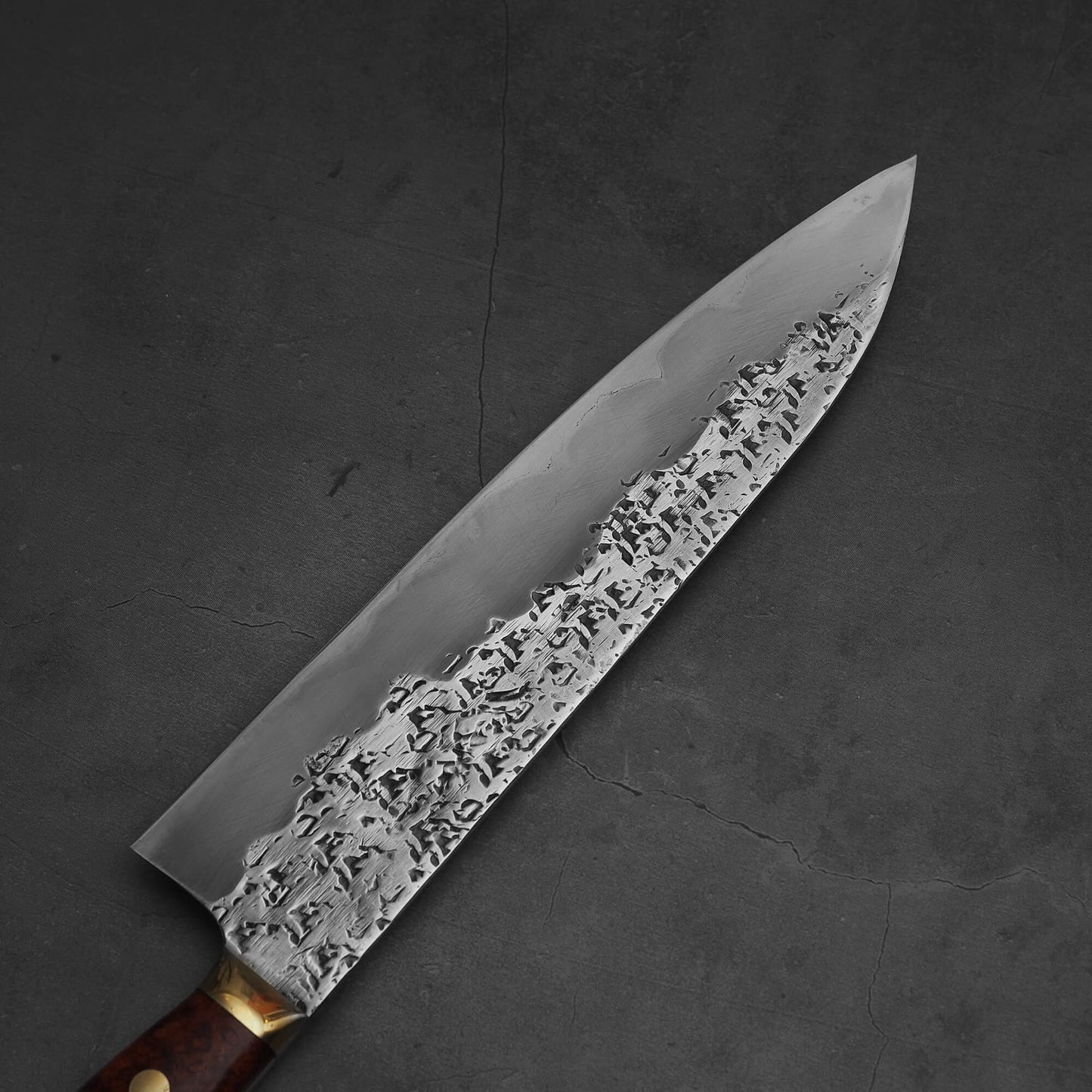 Top view of 240mm Kisuke Manaka tsuchime honwarikomi shirogami#2 gyuto knife. Image focuses on the left side of the knife
