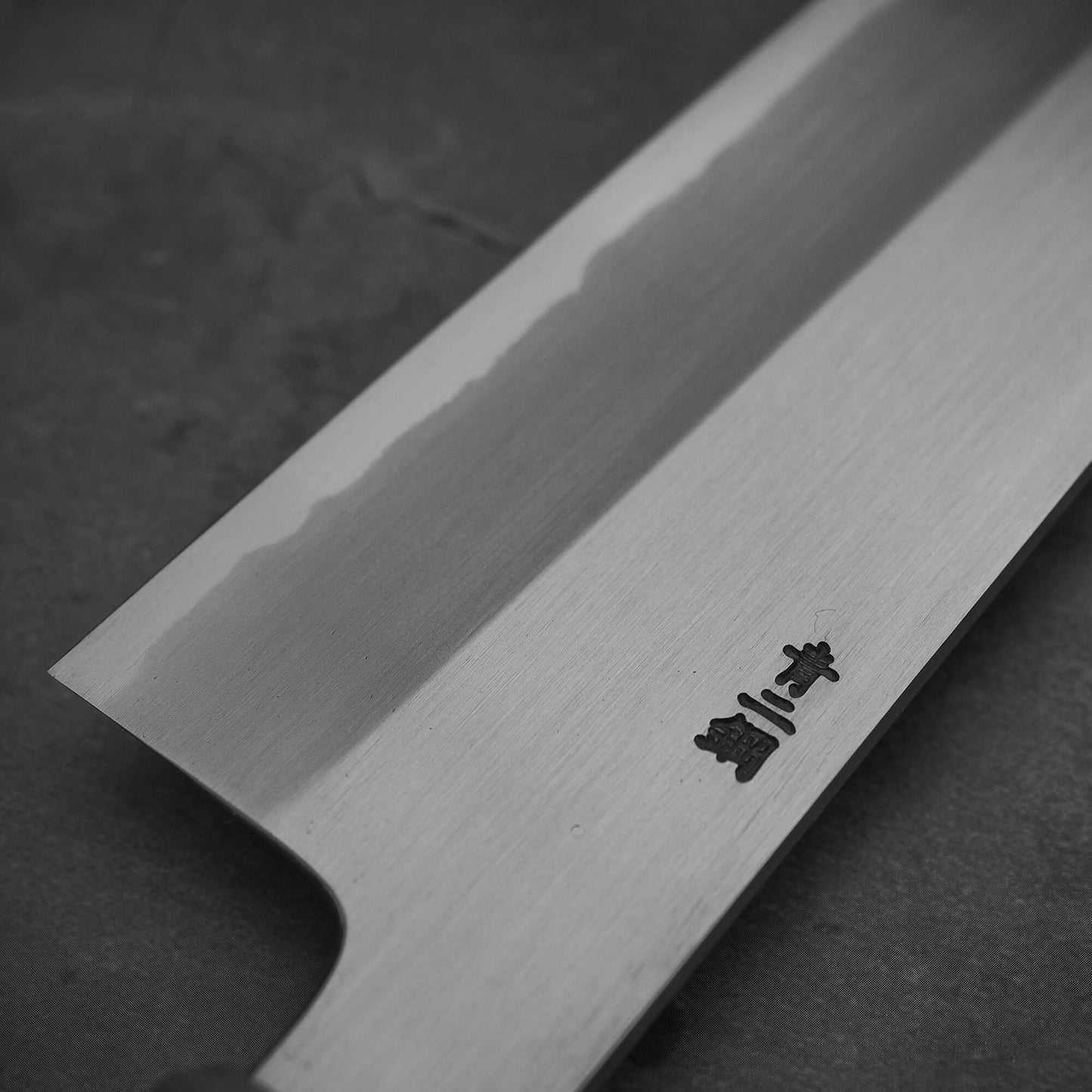Close up view of the back side of Nakagawa shinogi aogami#2 gyuto knife. Image shows left side of the blade