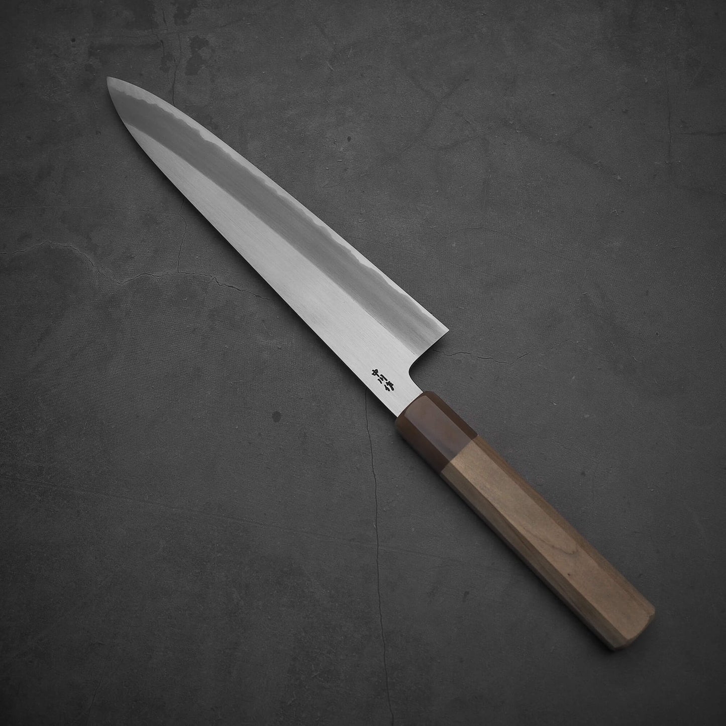 Top view of Nakagawa shinogi aogami#2 gyuto knife where the pointed tip is facing towards the upper left