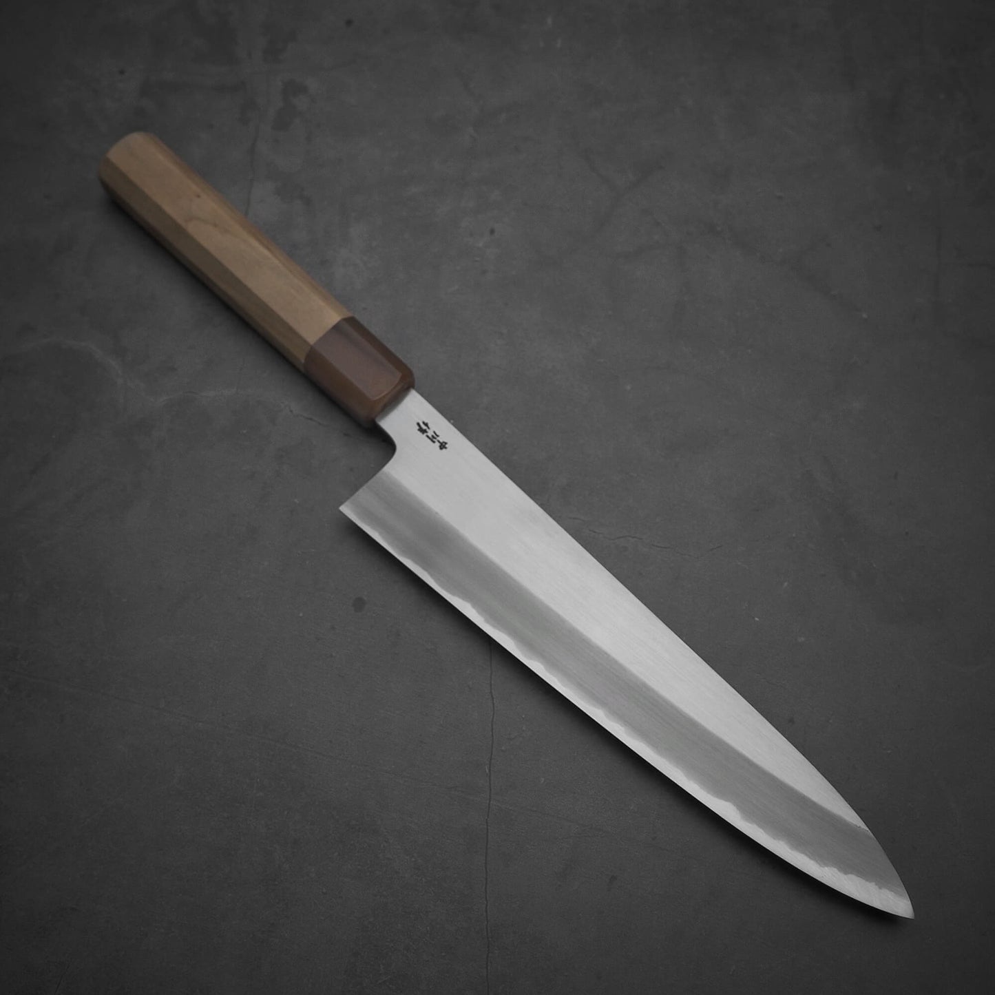Top view of the Nakagawa shinogi aogami#2 gyuto knife where the pointed tip is facing towards the lower right