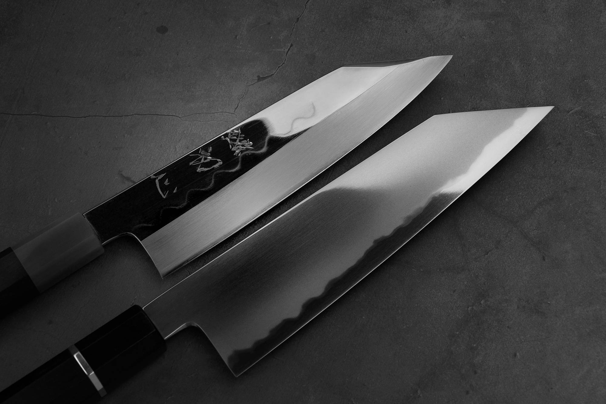 Top view of Nakagawa shirogami#3 honyaki bunka and Yoshikazu Tanaka AS bunka. The blades are in focus.