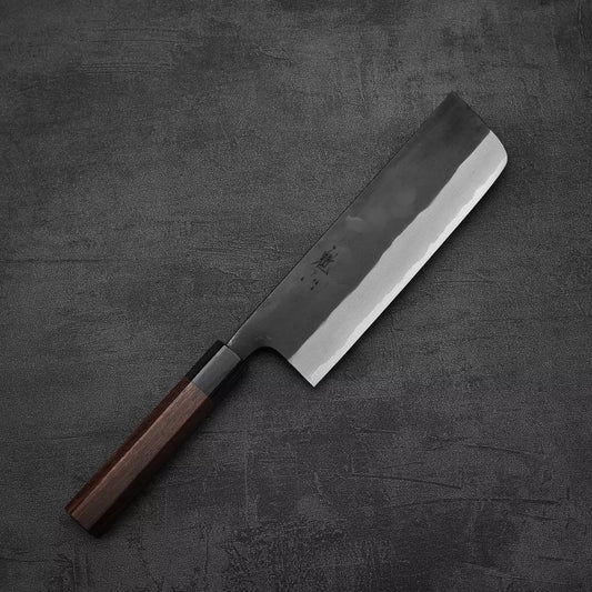 The Nao Yamamoto kurouchi aogami#2 nakiri 180mm, featuring a rectangular blade and dark wooden handle, rests on a textured dark gray surface.