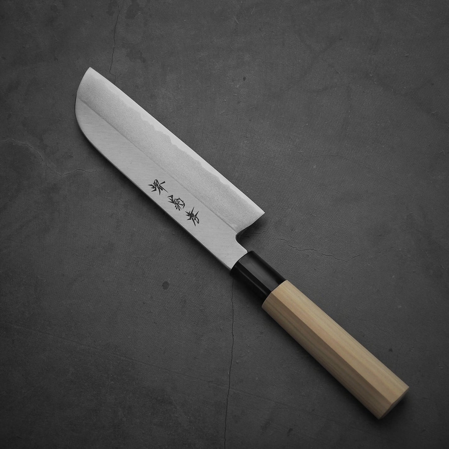 Top view of Sakai Takayuki shirogami#3 kamagata usuba knife where the pointed tip is facing towards the upper left. Image shows the front side of the knife