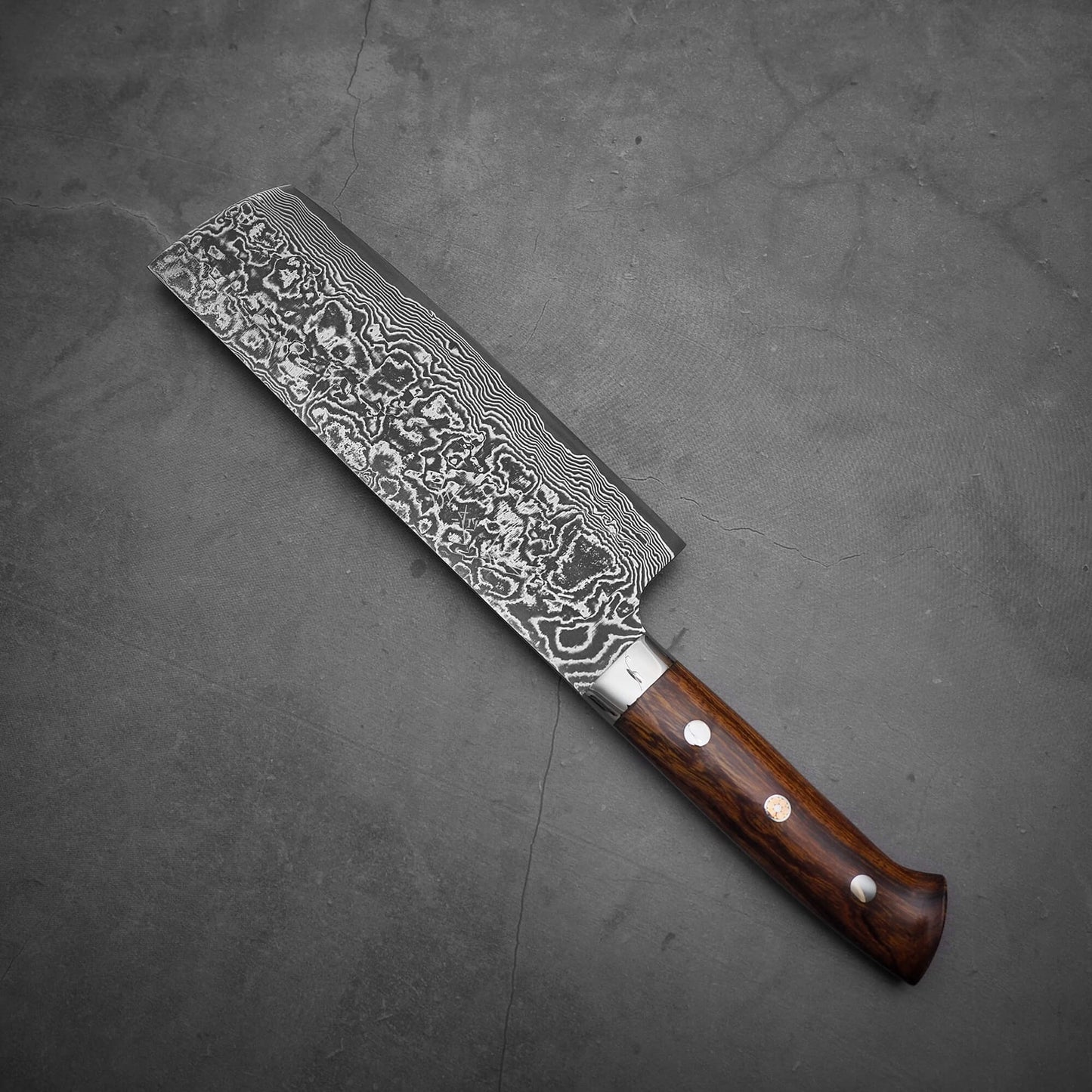 Top view of Takeshi Saji black damascus SG2 nakiri ironwood. The tip area faces the upper left