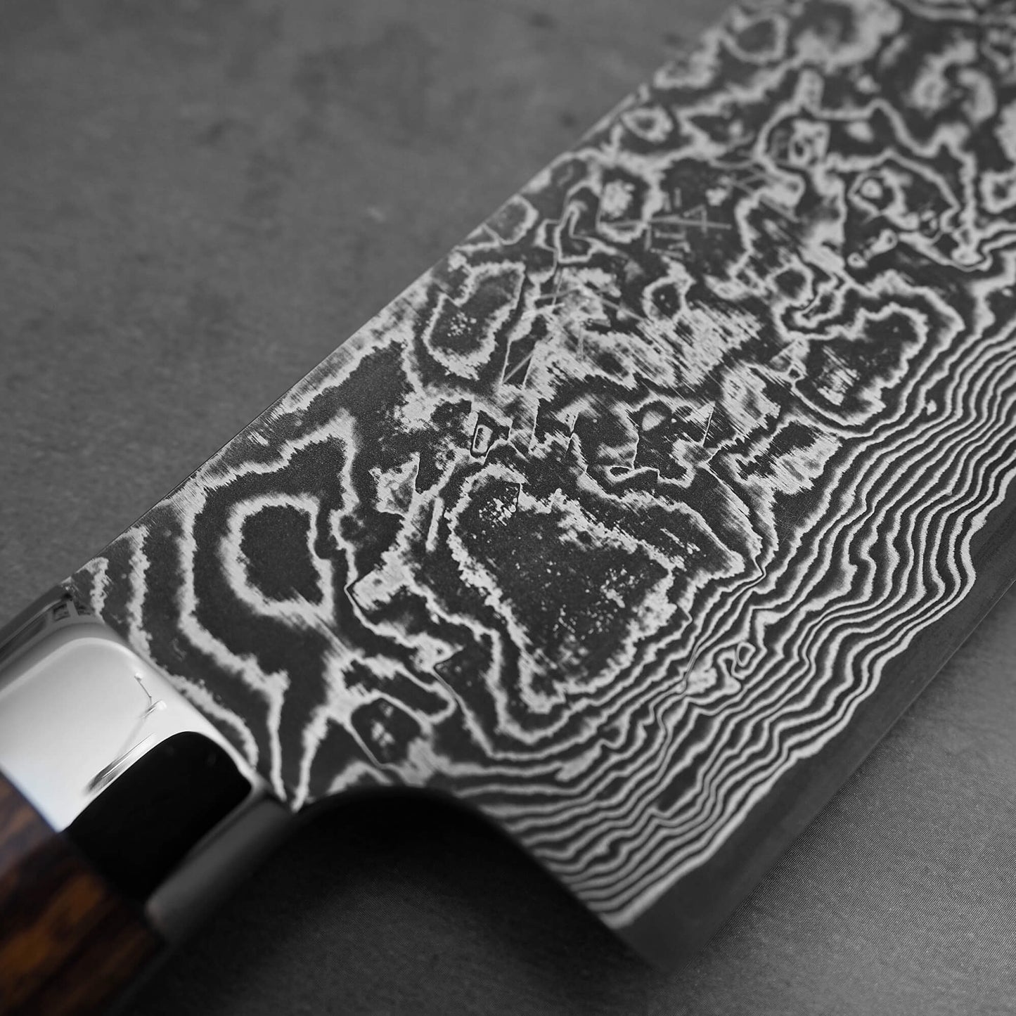 Close up view of Takeshi Saji black damascus SG2 nakiri ironwood. Image focuses on the kanji area