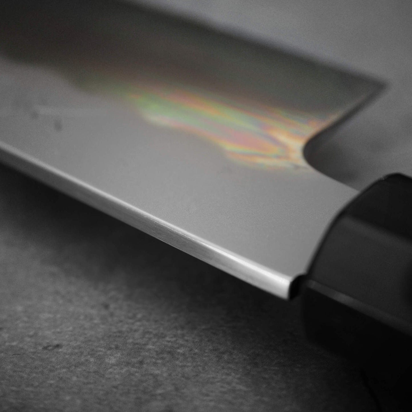 Close up view of Yoshikazu Ikeda shirogami#3 santoku 165mm. Image focuses on the spine area near the handle