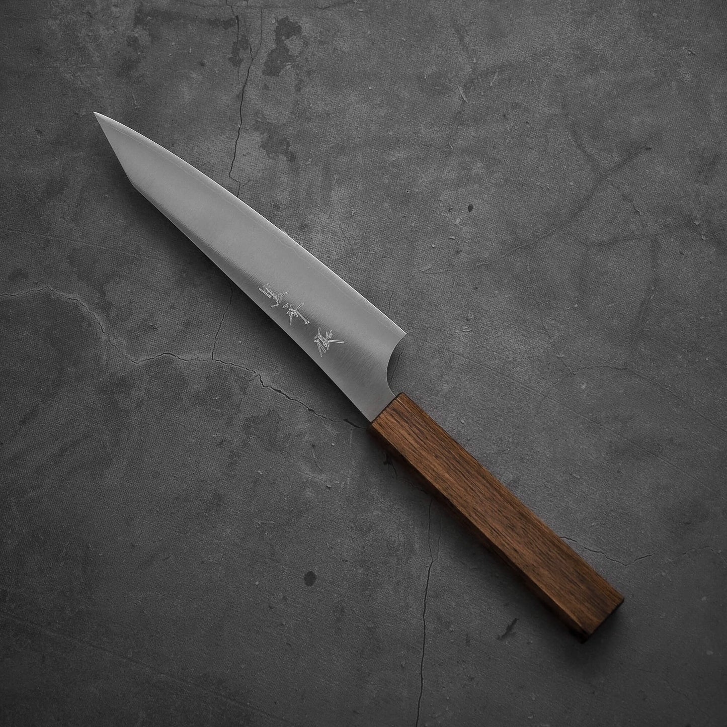 Top view of a Yu Kurosaki HAP40 Gekko petty knife. Pointed tip is facing towards the upper left.