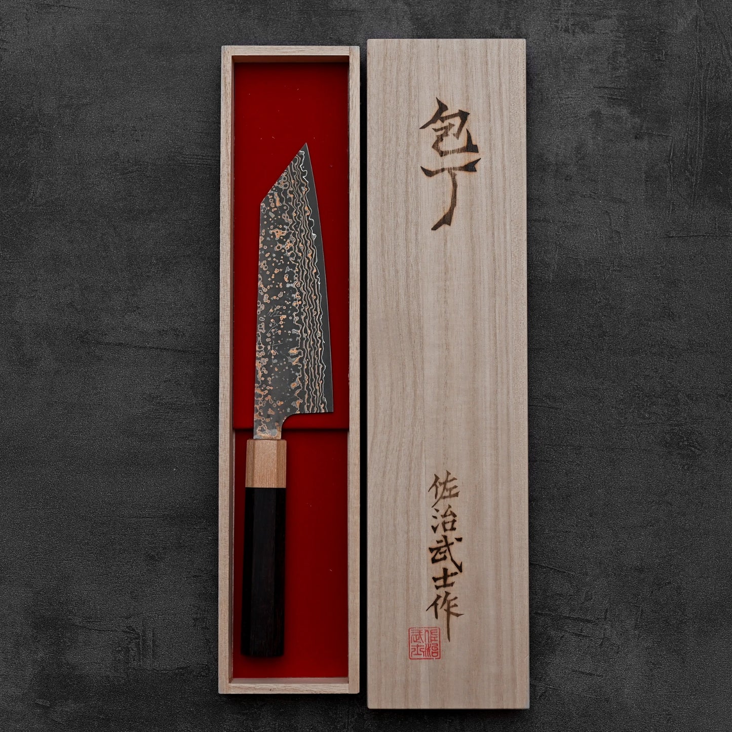 Top down view of Takeshi Saji VG10 Gold damascus bunka knife inside its kiri box