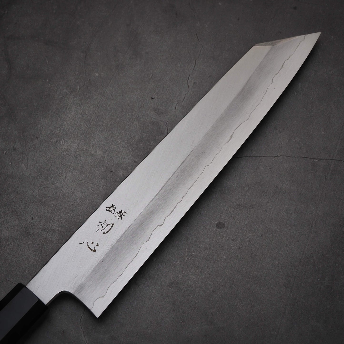 Close up view of the blade of Hatsukokoro Nakagawa ginsan kiritsuke gyuto knife. Image shows front side of the blade
