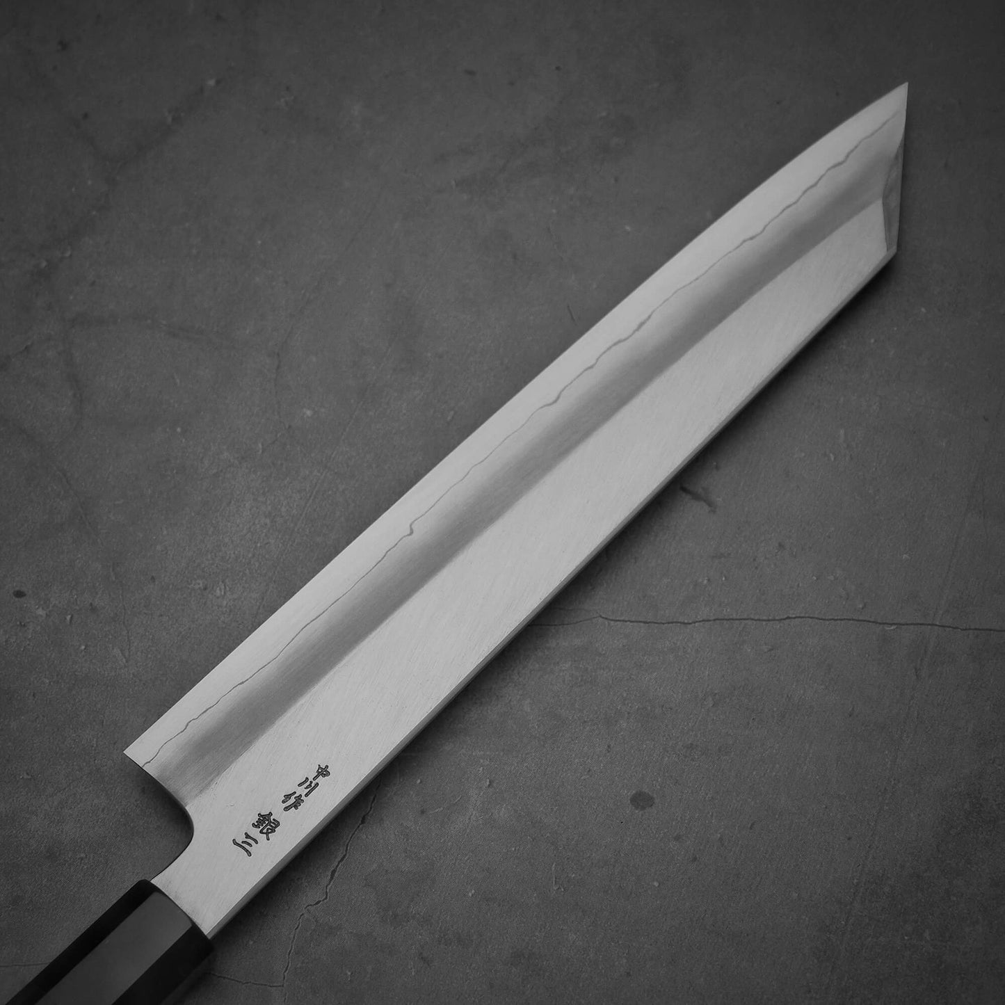 Close up view of the blade of the Hatsukokoro Nakagawa ginsan kiritsuke gyuto knife. Image shows left side of the knife