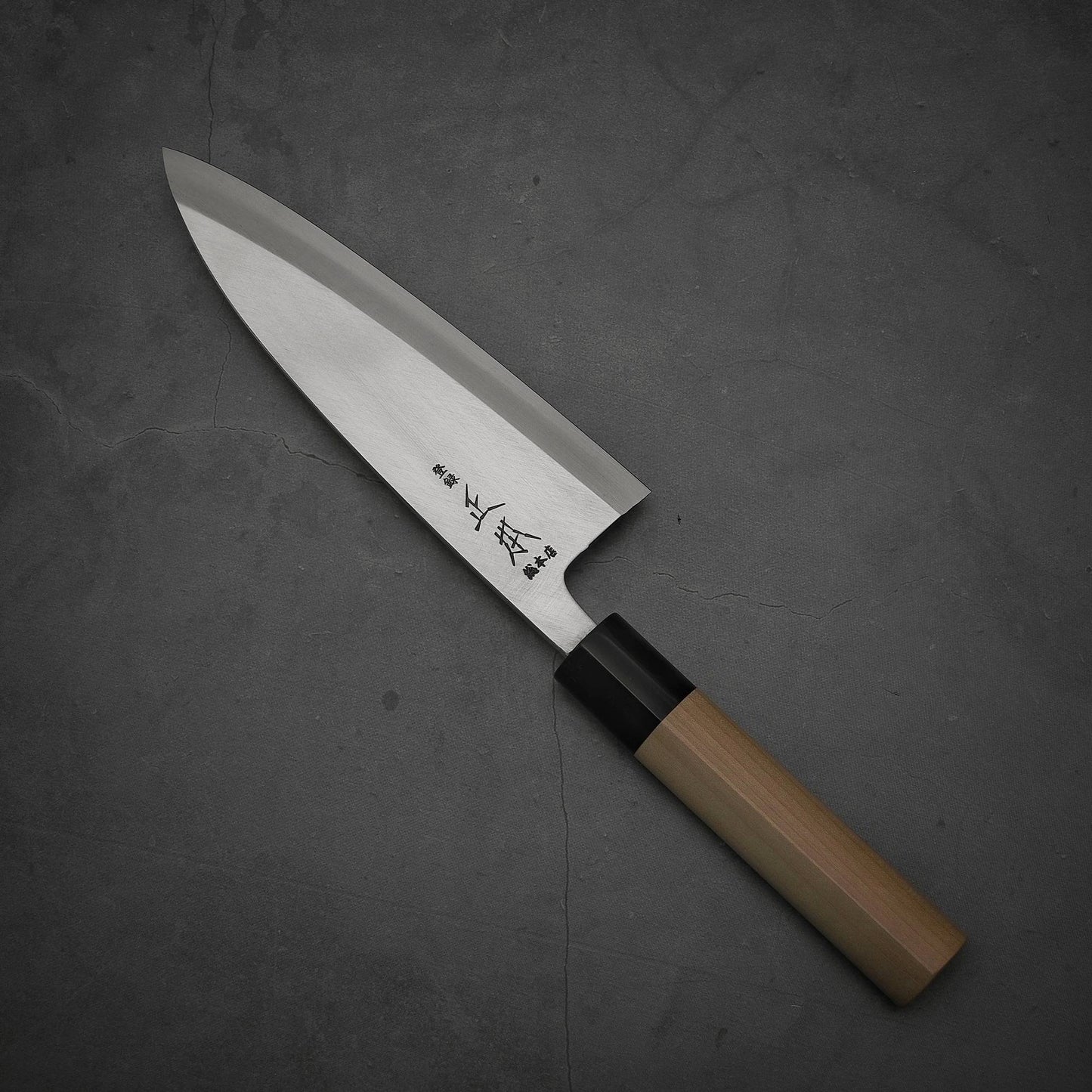 Top view of Masamoto KS shirogami#2 deba knife where pointed tip is facing towards upper left