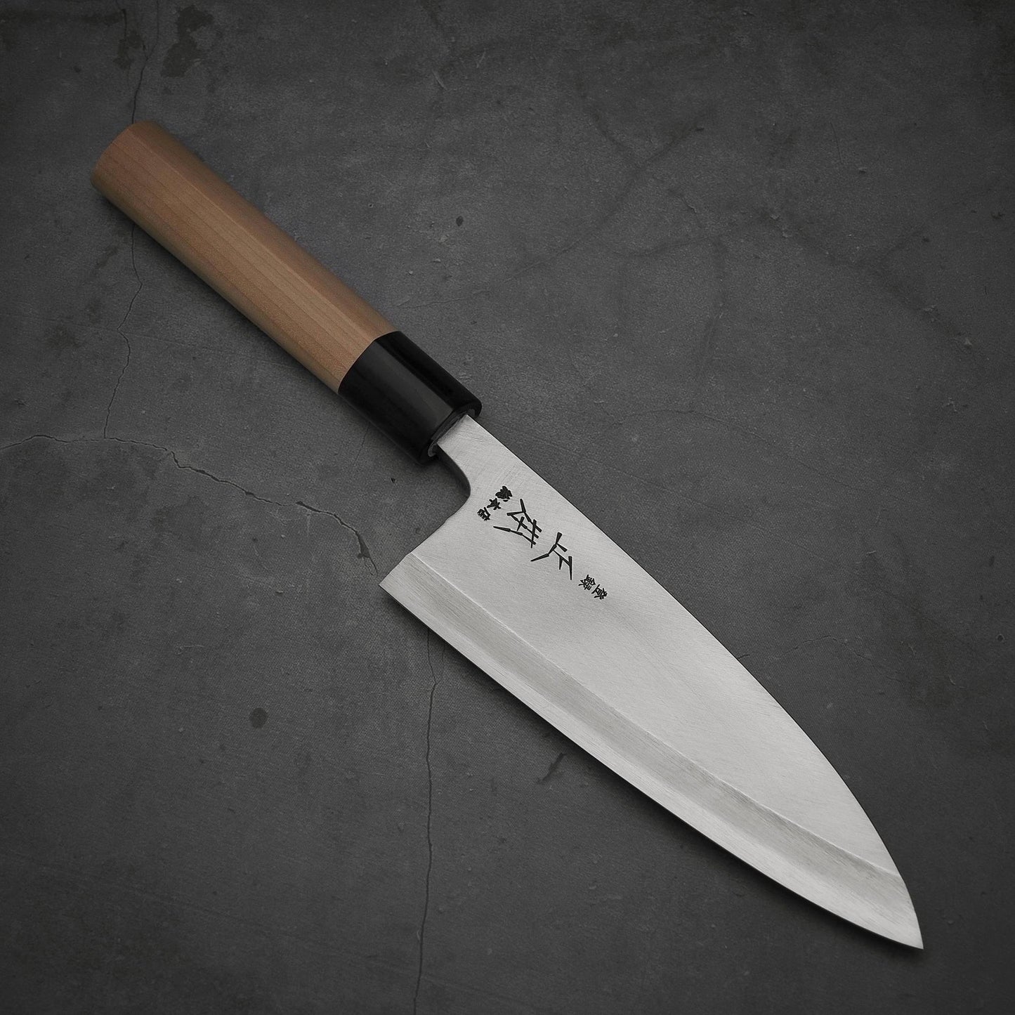 Top view of Masamoto KS shirogami#2 deba knife where pointed tip is facing towards lower right