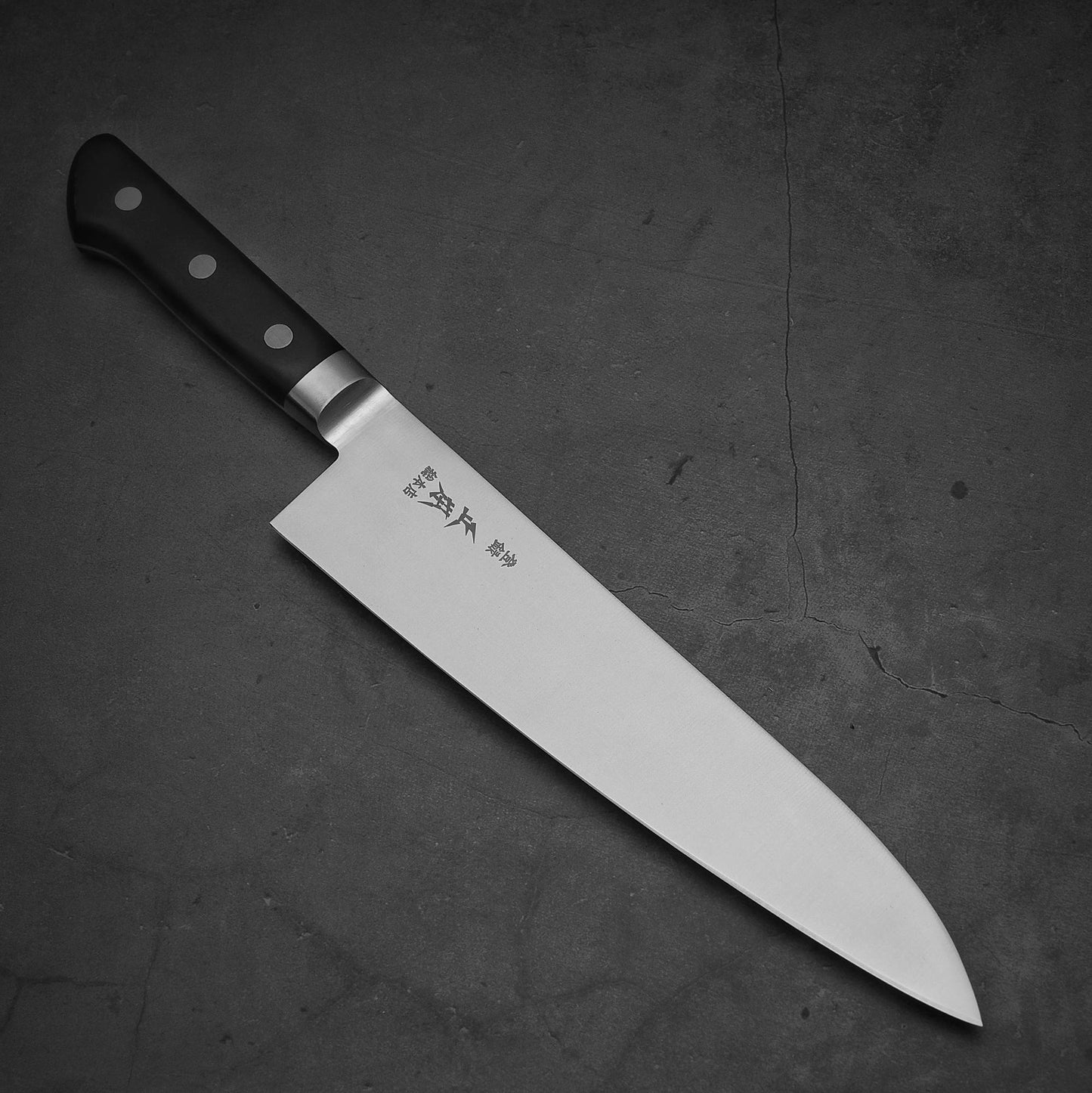 Top view of Masamoto VG yo-gyuto knife where pointed tip is facing towards lower right