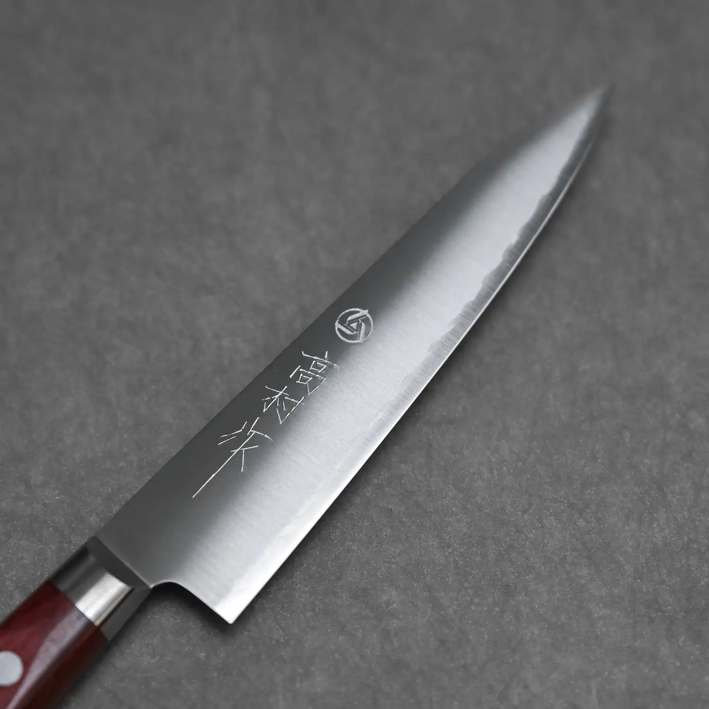 Close-up shot of the petty knife showing the front blade with kanji stamps