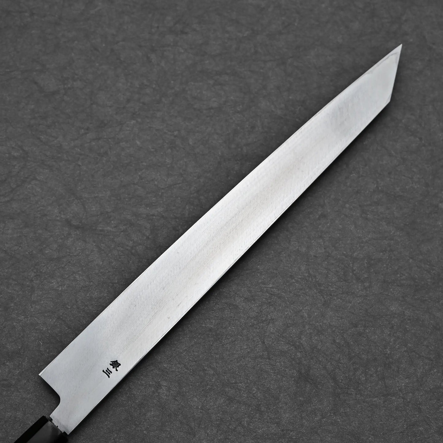 Angled view of the ktip yanagi showing the urasuki and steel stamp