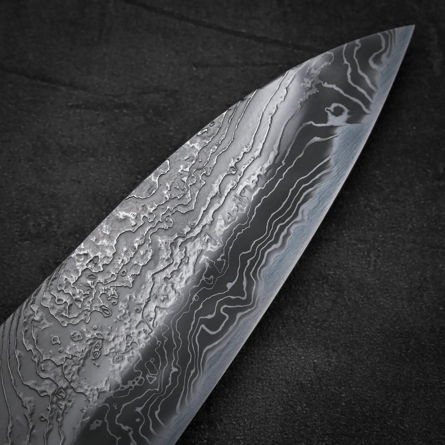 Macro shot of the tip area of Yoshihide Masuda shirogami#2 damascus tall gyuto knife