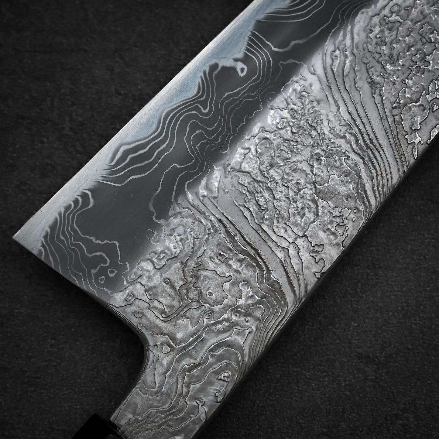 Macro shot of the back side of Yoshihide Masuda shirogami#2 damascus tall gyuto knife