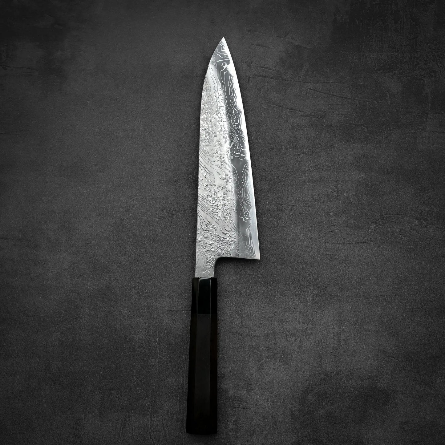 Top down view of Yoshihide Masuda shirogami#2 damascus tall gyuto knife in vertical position