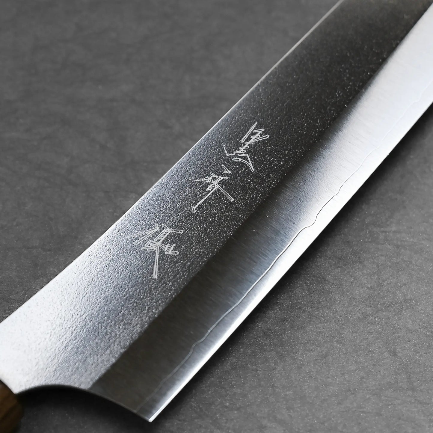 Macro detail of the maker's mark on the front blade