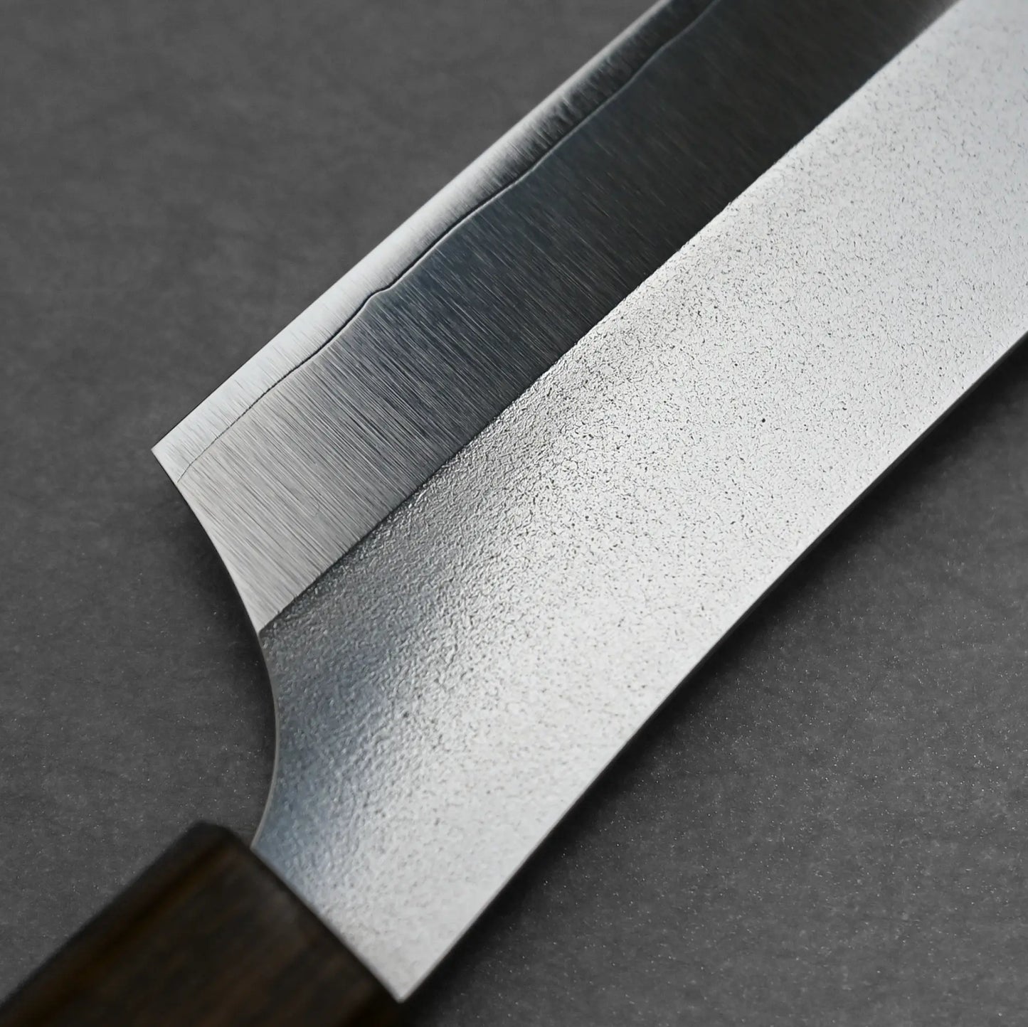Macro detail of the choil showing the back side of the kitchen knife