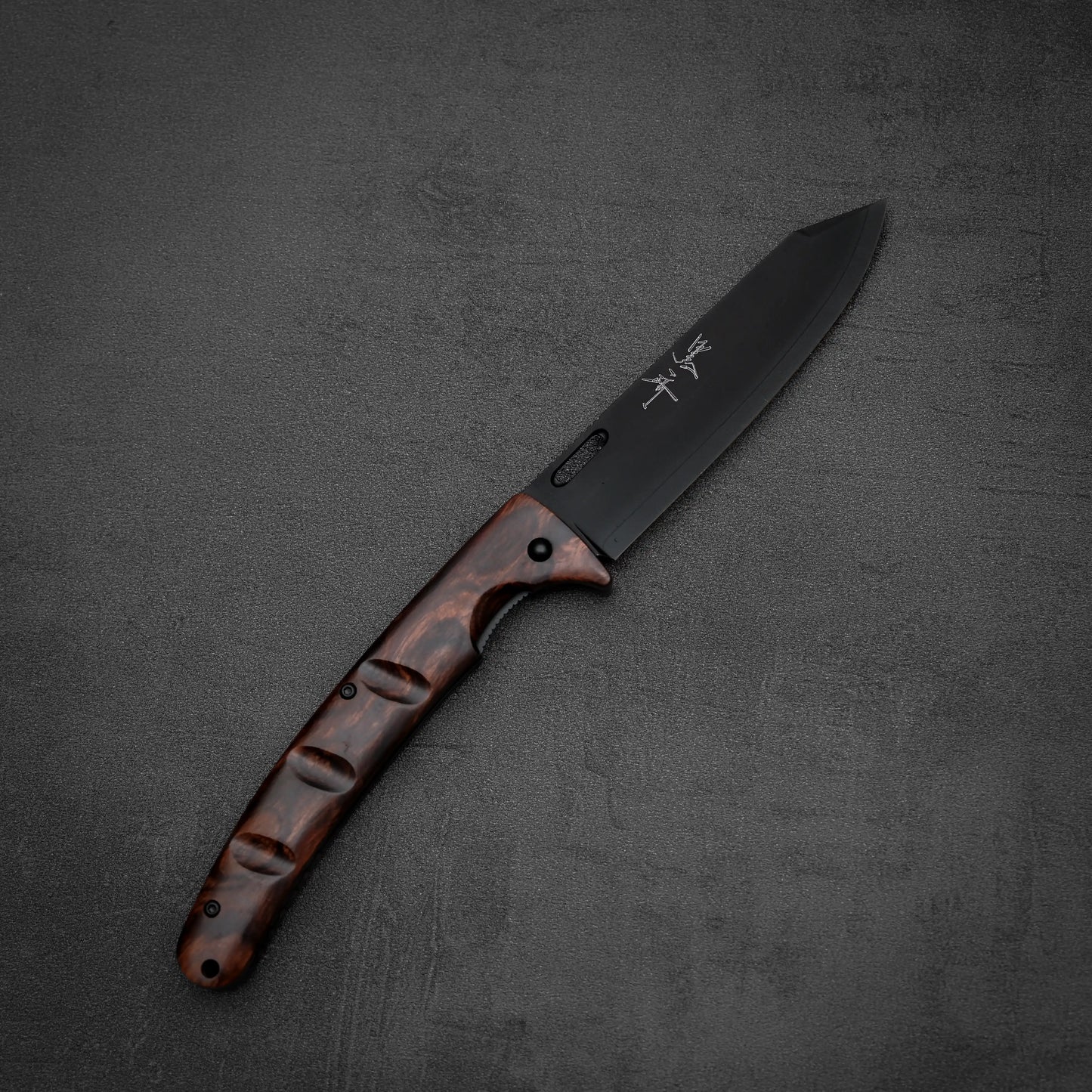 The Yu Kurosaki SG2 folding pocket knife features a black SG2 stainless steel blade and an ironwood handle, displayed open on a textured dark gray surface.