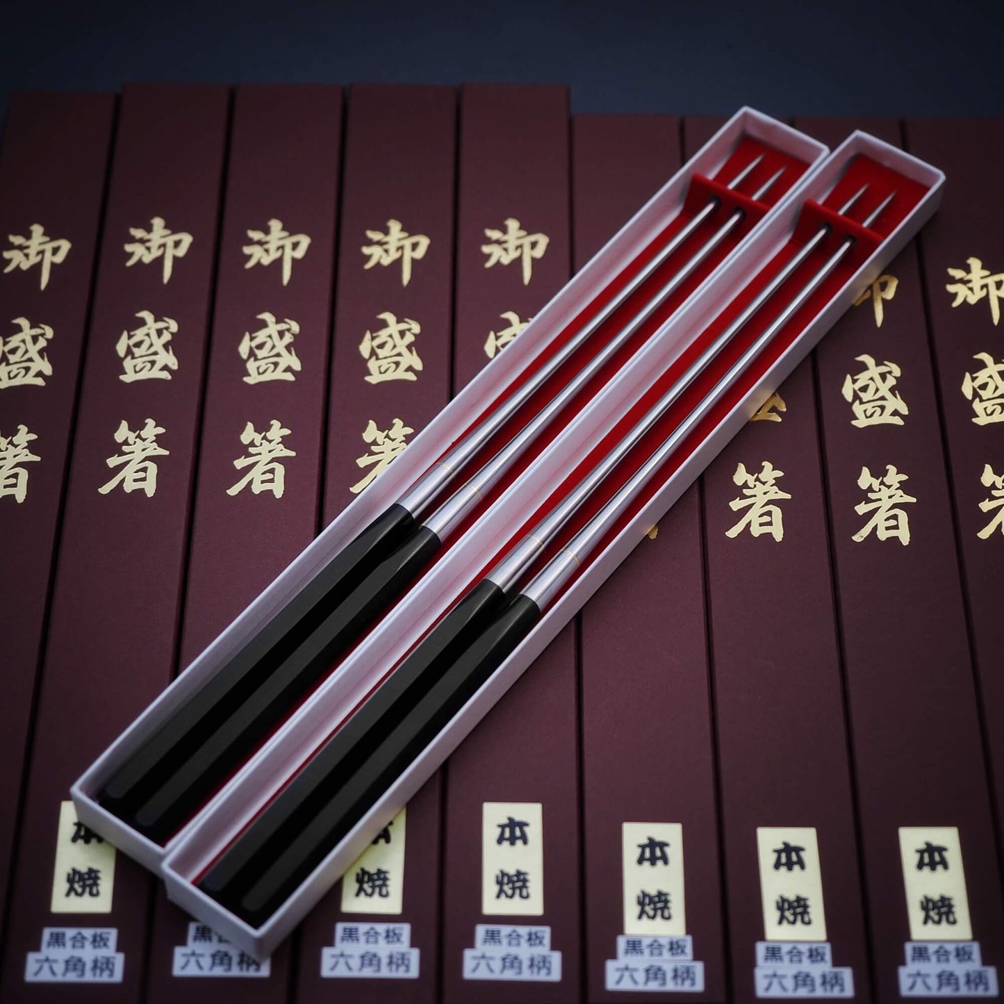 Top view of multiple 180mm moribashi plating chop sticks with hexagonal handle in their respective boxes