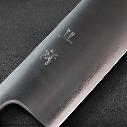 Close-up of a nakiri blade with kanji engraving, focusing on the detailed metal surface and characters.