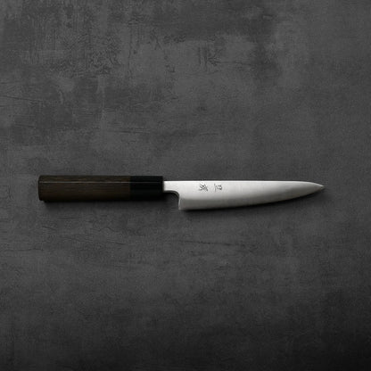 Petty knife with a dark handle and silver blade, showing subtle contrasts in materials and finish.