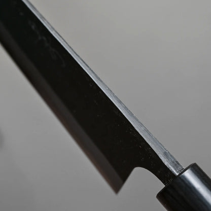 Close-up shot of the spine of 240mm Akifusa x Yamamoto tsuchime kurouchi damascus AS gyuto knife