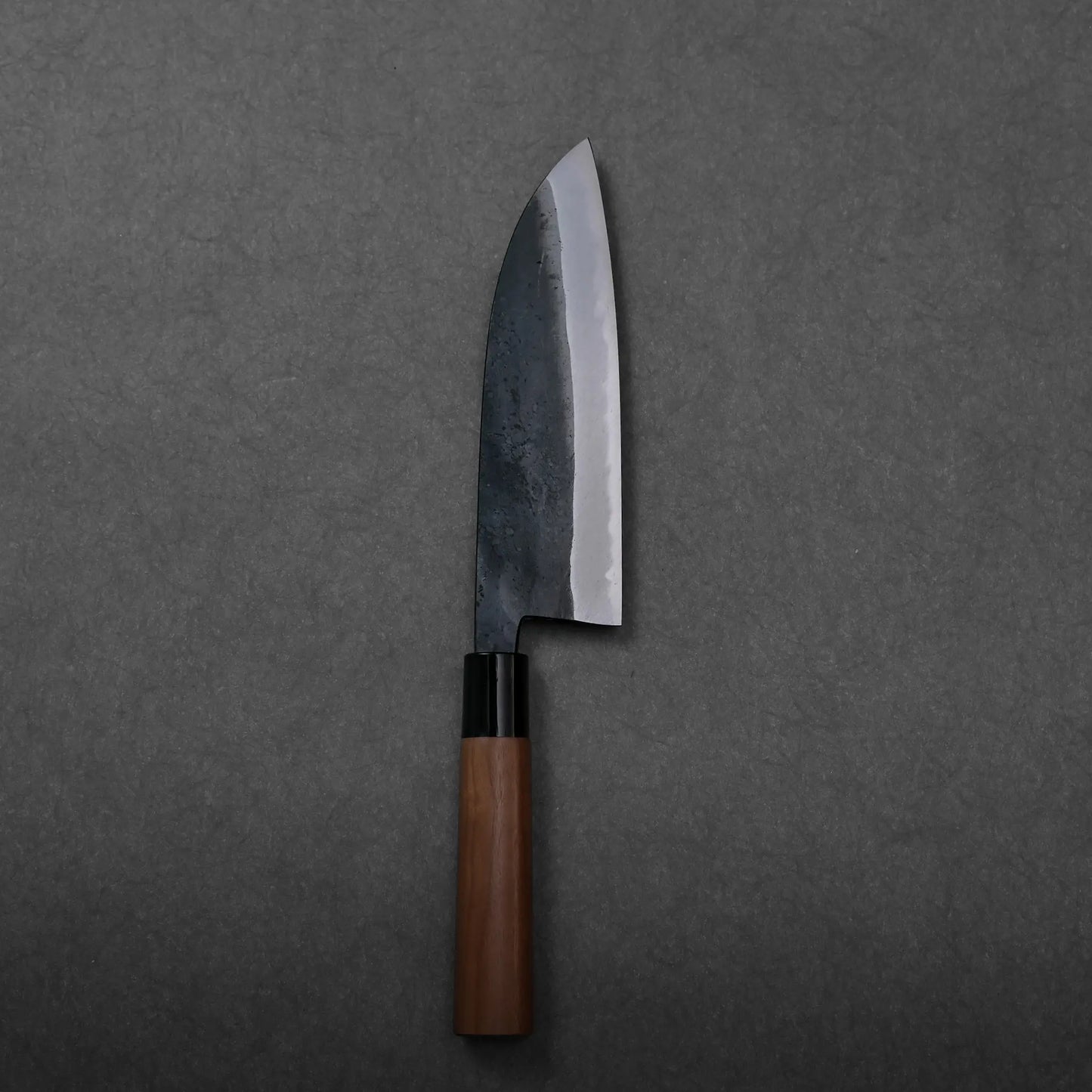 Close-up shows a dark blade and wooden handle of a Japanese knife; blade shape is not clearly visible.