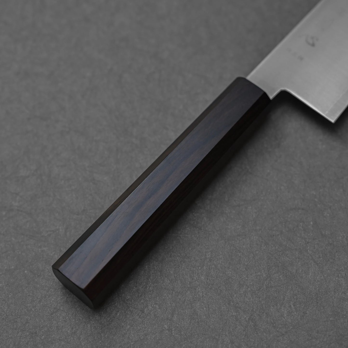Octagonal mono handle made of ebony wood; photographed to highlight the deep, dark finish, faceted geometry, and sleek craftsmanship of the single-piece design.