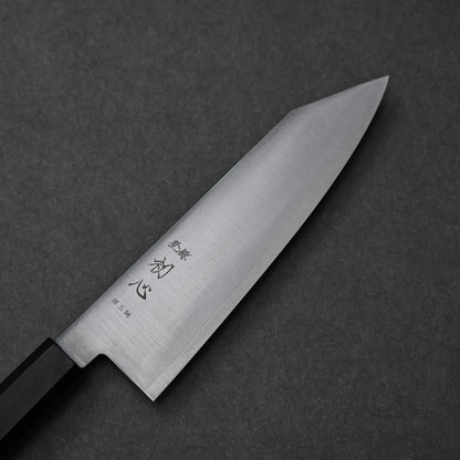 Close-up of a bunka knife made with ginsan stainless steel; photographed to highlight the pointed tip, vertically engraved kanji characters, and polished steel surface.