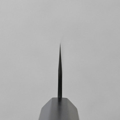 Close-up of a gyuto blade, 240mm, pointing upward with the edge and spine clearly visible.