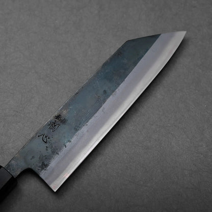 A black-handled Japanese knife, identifiable as a kiritsuke gyuto, features an angled blade with a flat edge.