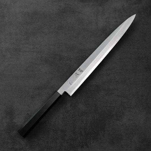 Hatsukokoro x Nakagawa aogami#1 yanagiba 300mm with a dark handle, showing distinct lines and polished finish under soft lighting.