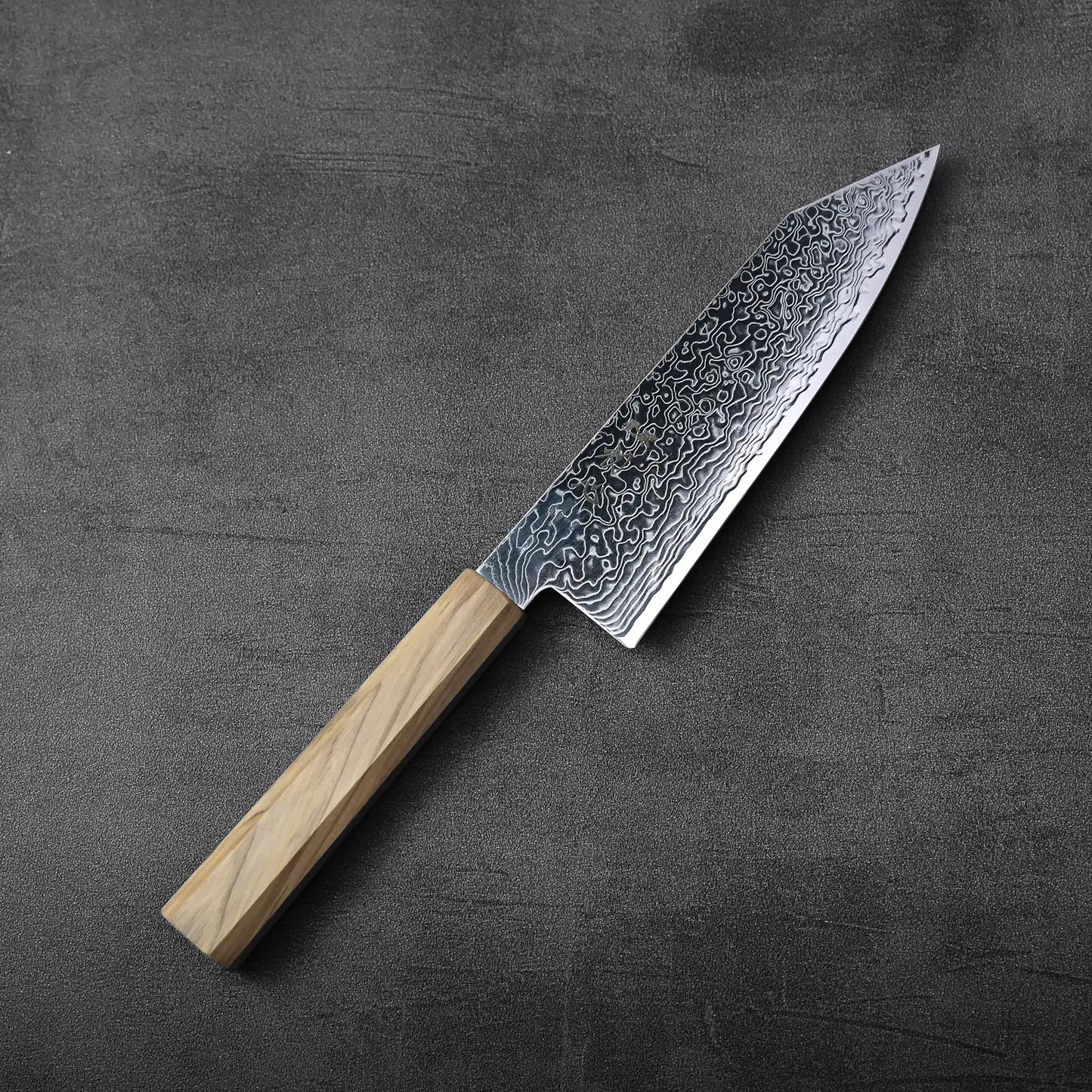 Bunka with a light wood handle displayed, showcasing detailed patterns along the blade’s surface.