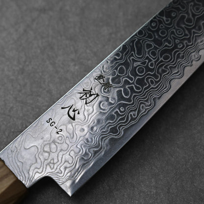 SG2 damascus petty knife with olive wood handle; photographed to highlight the blade’s intricate damascus pattern, engraved kanji near the SG2 steel marking, and the smooth grain of the olive wood handle. Set against a neutral background to emphasize the blade details.